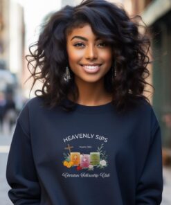 Navy blue sweatshirt with Three faith-inspired juice glasses: Joyful Juice (orange with a cross), Blessed Berry (pink with a dove), and Graceful Green (green with a fish).