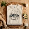 Sand colored folded t-shirt with picture of night sky and the quote, 
