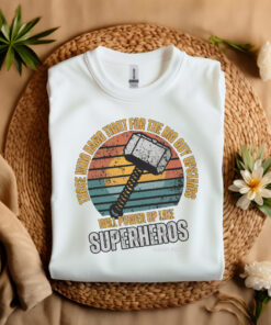 White Gildan T-shirt folded laying on a straw hat Superhero design