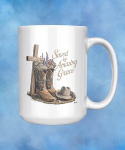 Coffee mug with a cross and cowboy hat and boots filled with flowers with Saved by Grace on it