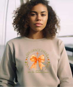 Woman wearing a Gildan 1800 sand colored sweatshirt with Design that says His Grace Falls Like The Autumn Leaves