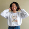 An African American woman wearing a white Gildan 1800 sweatshirt His Grace Falls Like Autumn Leaves