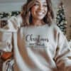 A-young-woman-in-a-sand-colored-Gildan-1800-Sweatshirt-that-saysChristmas-Gods-Relentless-Love-For-U