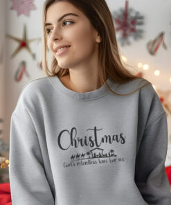 A-young-woman-wearing-a-sport-grey-Gildan-1800-sweatshirt-that-saysChristmas-Gods-Relentless-Love-For-Us