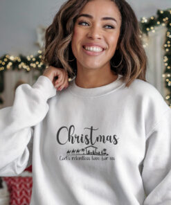 Young woman in white Gildan 1800 sweat shirt that saysChristmas Gods Relentless Love For Us