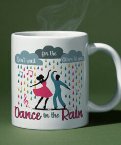 Colorful coffee mug featuring dancers in the rain with the inspirational phrase "Don’t wait for the storm to pass, dance in the rain."