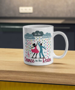 Colorful coffee mug featuring dancers in the rain with the inspirational phrase 