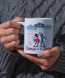 Colorful coffee mug featuring dancers in the rain with the inspirational phrase "Don’t wait for the storm to pass, dance in the rain."