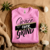 Pink Gildan 5000 Grace Over Grind t-shirt features bold calligraphy, gold and black brushstrokes, and an inspirational Christian faith message