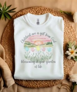 White Flat fold Children Are a Gift From God Floral Christian T-Shirt featuring a watercolor sunrise, handprint flowers, and faith-based quote.