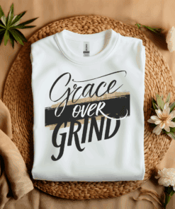 White Gildan 5000 Grace Over Grind t-shirt features bold calligraphy, gold and black brushstrokes, and an inspirational Christian faith message