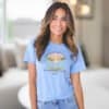 Blue Children Are a Gift From God Floral Christian T-Shirt featuring a watercolor sunrise, handprint flowers, and faith-based quote.